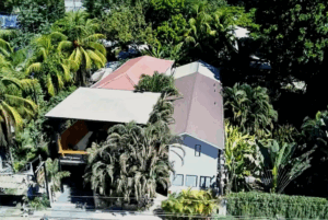 Aerial view of a tropical house surrounded by lush greenery.
